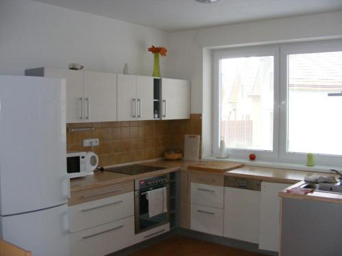 a kitchen with white cabinets and a white refrigerator at Holiday Home Lipno Frymburk in Frymburk