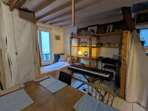 - un salon avec un piano et un bureau dans l'établissement Loft authentique et bohème - Montorgueil, à Paris