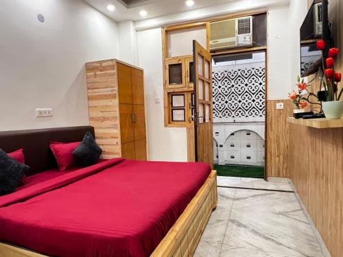 a bedroom with a large red bed in a room at Divine Inn Hotel Near Rajouri Garden Main Market in New Delhi