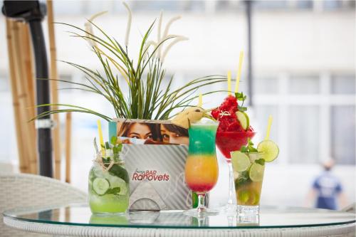 a table with two cocktails and a potted plant at Hotel Rahovets in Gorna Oryakhovitsa