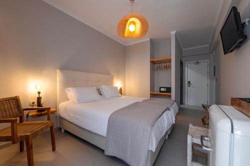 a bedroom with a large white bed and a tv at Avra in Parga