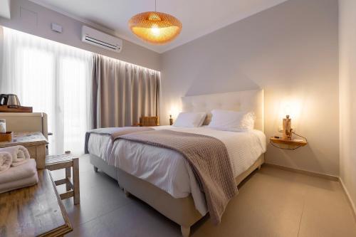 a bedroom with a large bed with white sheets at Avra in Parga