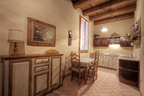 uma cozinha com mesa e cadeiras num quarto em La Fornasaccia em Cesena