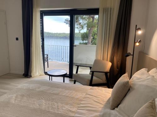 een slaapkamer met een bed en uitzicht op het water bij Apartments & Rooms Bianca in Mali Lošinj