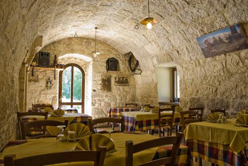 um restaurante com mesas e cadeiras e uma parede de pedra em Agriturismo Tholos em Roccamorice