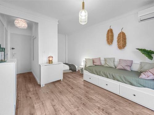 une chambre blanche avec un lit et un parquet dans l'établissement Confort et Vue sur Mer à Canet, à Canet