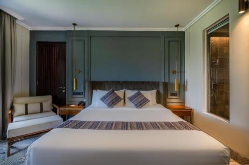 a bedroom with a large bed and a chair at Sense Canggu Beach Hotel in Canggu