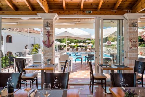 a restaurant with tables and chairs and a pool at Marietta's Resort by Konnect, Gouvia Corfu in Gouvia