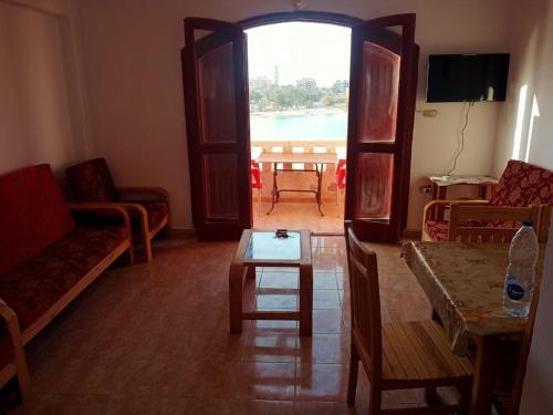 a living room with a table and a view of a pool at مرسي مطروح in Marsa Matruh