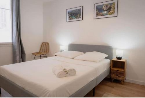 - une chambre avec un lit avec des draps blancs et une table dans l'établissement Sublime T4 au cœur du Panier proche du Vieux Port - 13EVE, à Marseille