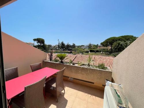 une table et des chaises roses sur un balcon dans l'établissement SUPERBE APPARTEMENT Terrasse PISCINE ET TENNIS, à Antibes