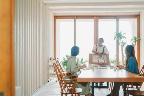a group of people sitting around a table in a room at Colorit GOTO ISLANDS in Goto