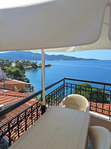 a table and chair on a balcony with a view of the ocean at Akrotiri Hotel in Neos Marmaras