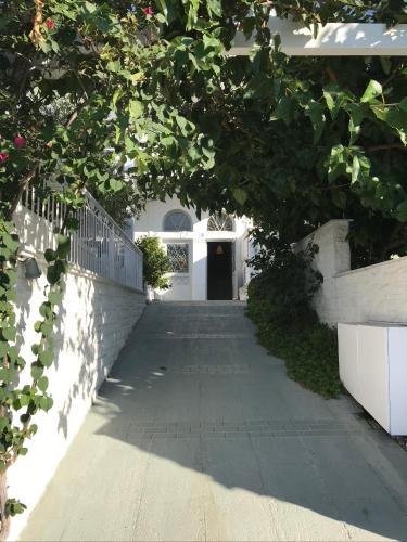 a walkway leading to a white building with a doorway at Paradisos in Áyioi Pándes