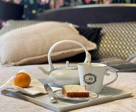 a tray with a tea cup and a piece of cake at Domaine Albizia in Livry