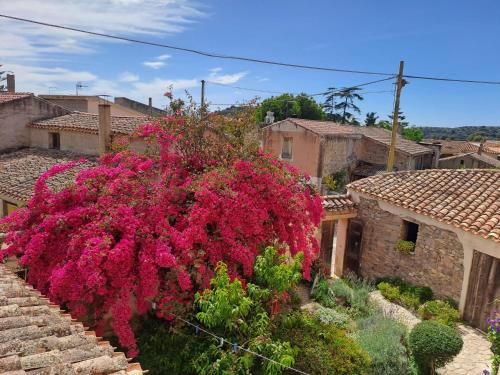 a large bush of pink flowers on a building at B&B S'Omu Antiga in Nureci
