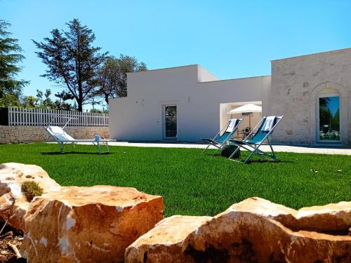 a house with two lawn chairs in a yard at Pietra Di Puglia in Monopoli