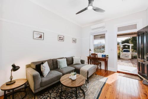 a living room with a couch and a table at Kialla Cottage - An Idyllic Country Escape in Mudgee