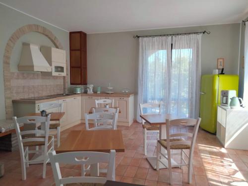 a kitchen with a table and chairs and a refrigerator at Il Casolare Country House in Fontecorniale