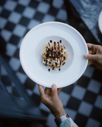 a person holding a white plate with food on it at Puris Moedani Boutique Hotel in Tbilisi City
