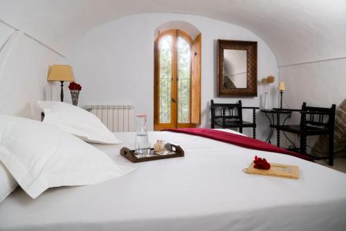 a bedroom with a white bed with a tray on it at Can Serola in Sales del Llierca
