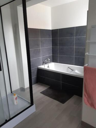 une salle de bain avec une baignoire et un lavabo dans l'établissement La maison bord de mer, à Trévou-Tréguignec