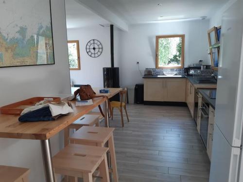 une cuisine avec une table et des chaises dans une pièce dans l'établissement La maison bord de mer, à Trévou-Tréguignec