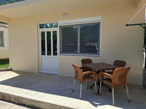 a table and chairs in front of a house at Apartman Lazovic Prcanj in Kotor
