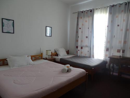 a bedroom with two beds and a window at Radama Hotel in Antananarivo