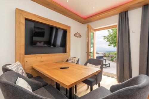 a dining room with a wooden table and chairs at Das Salzburgblick in Ainring