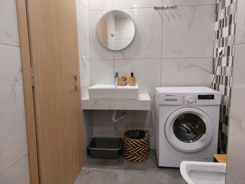 a bathroom with a washing machine and a sink at Apartments Avia in Limenaria