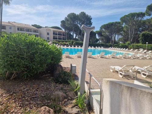 un complexe avec une piscine avec des chaises et une perche dans l'établissement domaine de valescure, à Saint-Raphaël