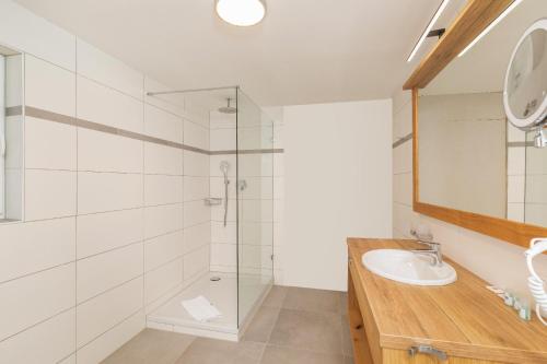 a bathroom with a glass shower and a sink at Das Salzburgblick in Ainring