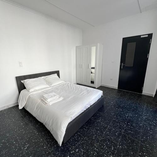 a white bed in a room with a black floor at Suite studio entier St Charles, Canebiere, Vieux-Port Appartement in Marseille