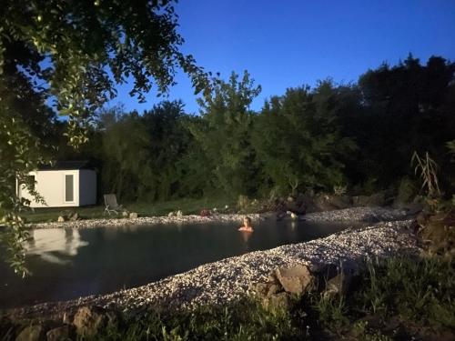 a person swimming in a river with a trailer at Farm Ház in Fonyód