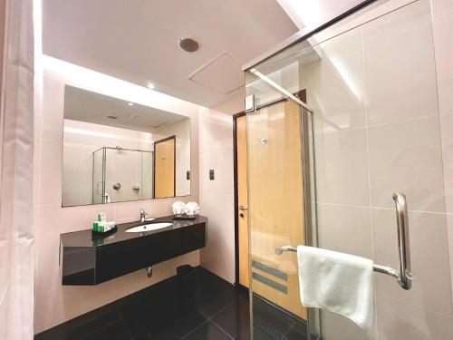 a bathroom with a sink and a shower at Imperial Hotel Kuching in Kuching