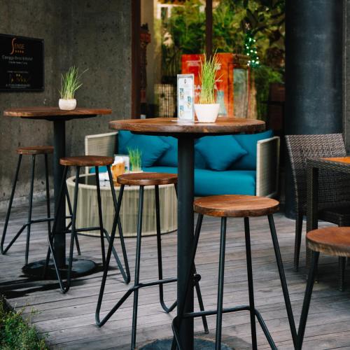 a group of tables and stools on a patio at Sense Canggu Beach Hotel in Canggu