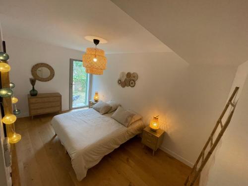 une chambre avec un lit avec des draps blancs et une fenêtre dans l'établissement Superbe appart neuf centre ville 6 personnes calme avec jardin, à Sainte-Maxime