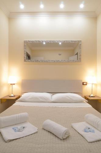 a bedroom with a large bed with towels on it at Dependance Ludovica in Termoli