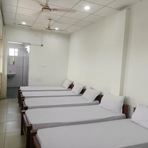 a row of beds in a room at Grace Tourist Home in Ernakulam
