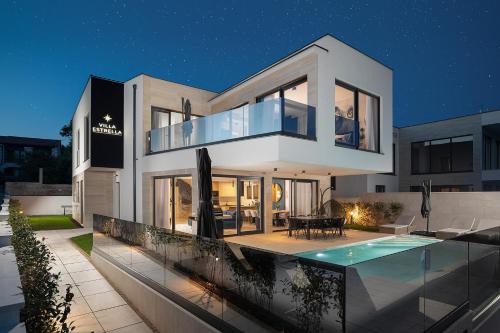 a modern house with a swimming pool at night at Villa Estrella in Medulin for 10 people with sauna & whirpool just 6 m from the sea in Medulin