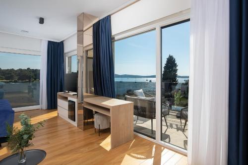 a living room with a desk and large windows at Villa Estrella in Medulin for 10 people with sauna & whirpool just 6 m from the sea in Medulin