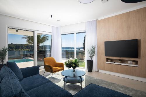 a living room with a blue couch and a tv at Villa Estrella in Medulin for 10 people with sauna & whirpool just 6 m from the sea in Medulin