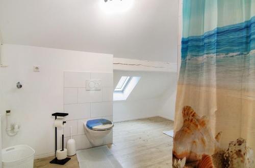 a bathroom with a toilet and a shower curtain at Ferienwohnung am Schlosssee in Salem