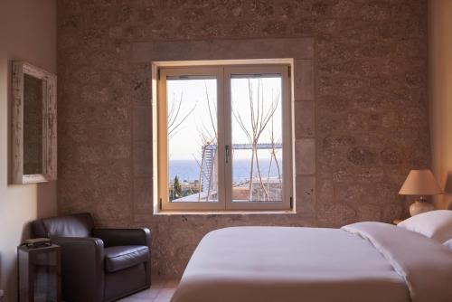 a bedroom with a bed and a chair and a window at Riglia Villas in Riglia