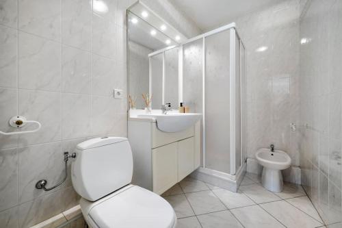 une salle de bain blanche avec des toilettes et un lavabo dans l'établissement Victoria Beach - Charmant studio hyper centre ville de Menton - Mer au pied de l'immeuble, à Menton