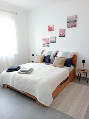a bedroom with a large bed with white walls at Lind-Appartments in Villach