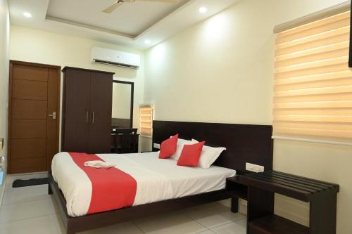 a bedroom with a bed with red and white pillows at Grace Tourist Home in Ernakulam