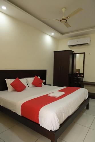 a bedroom with a large bed with red pillows at Grace Tourist Home in Ernakulam