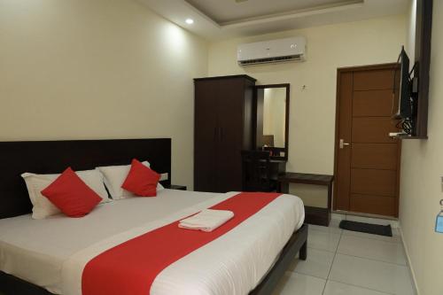 a bedroom with a large bed with red and white pillows at Grace Tourist Home in Ernakulam